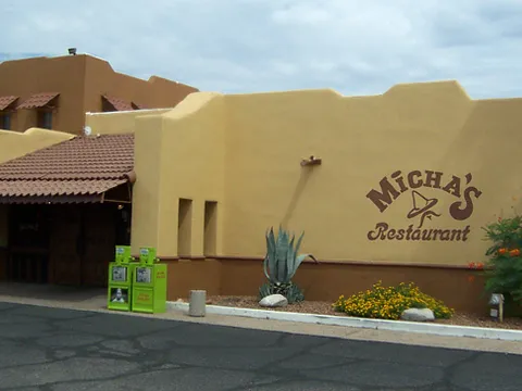 The tan adobe-style exterior of Micha's Restaurant in South Tucson with the 'Micha's Restaurant' name painted on the wall and agave and desert landscaping out front